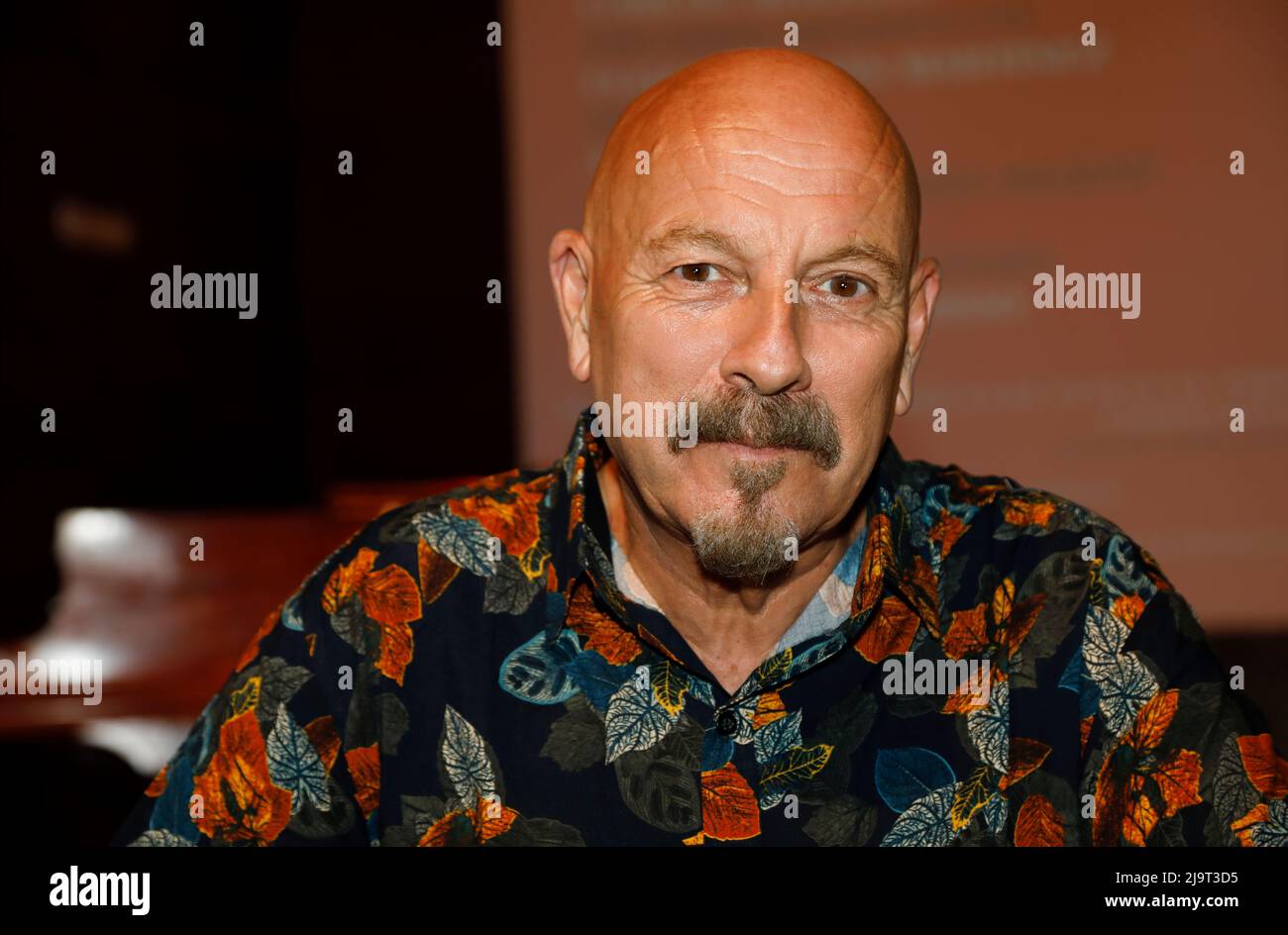 Close-up portrait, looking at the camera of Spanish singer, composer and arranger Javier Ruibal, with out-of-focus background indoors. Stock Photo