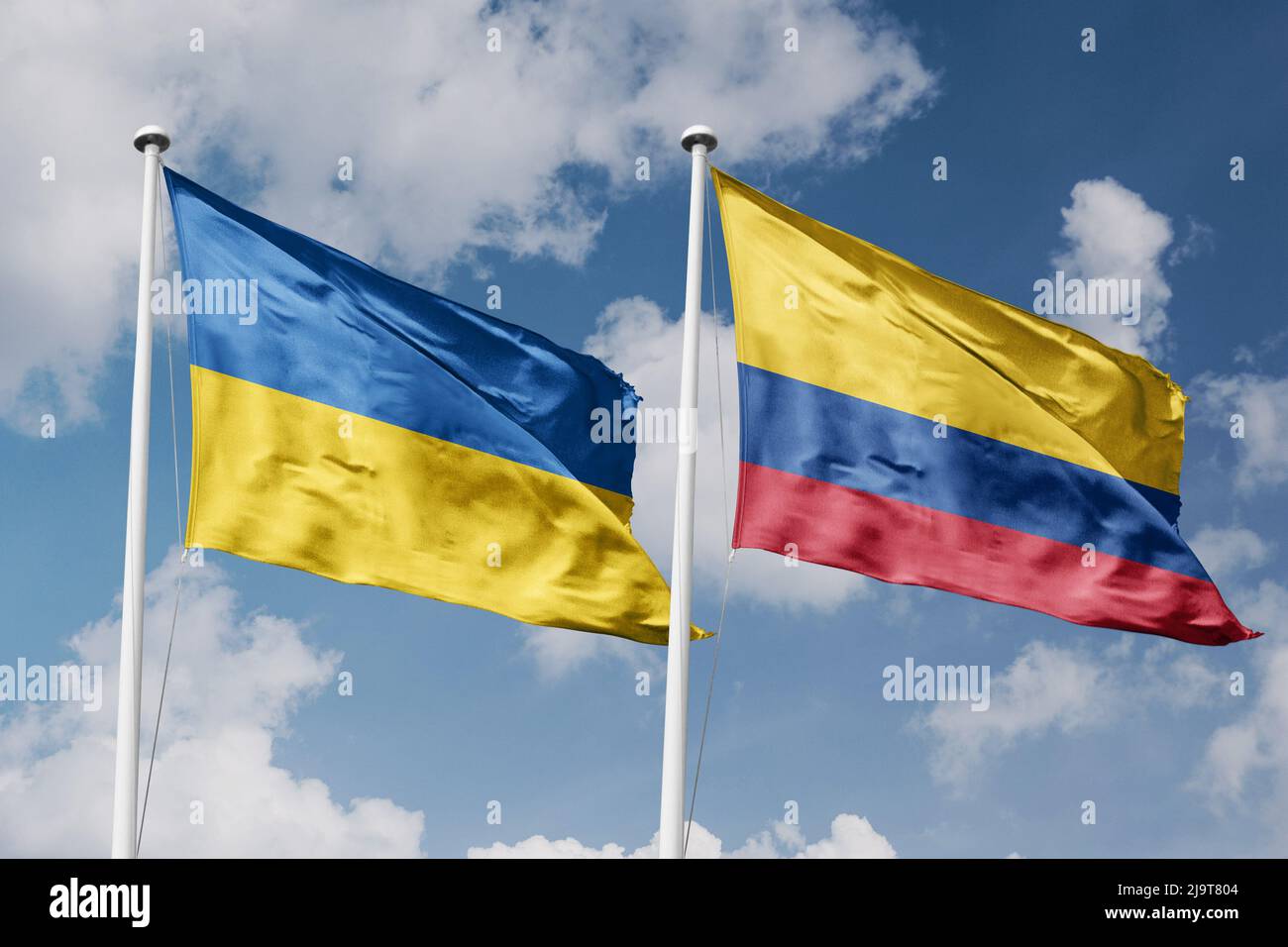 Ukraine and Colombia two flags on flagpoles and blue cloudy sky background Stock Photo