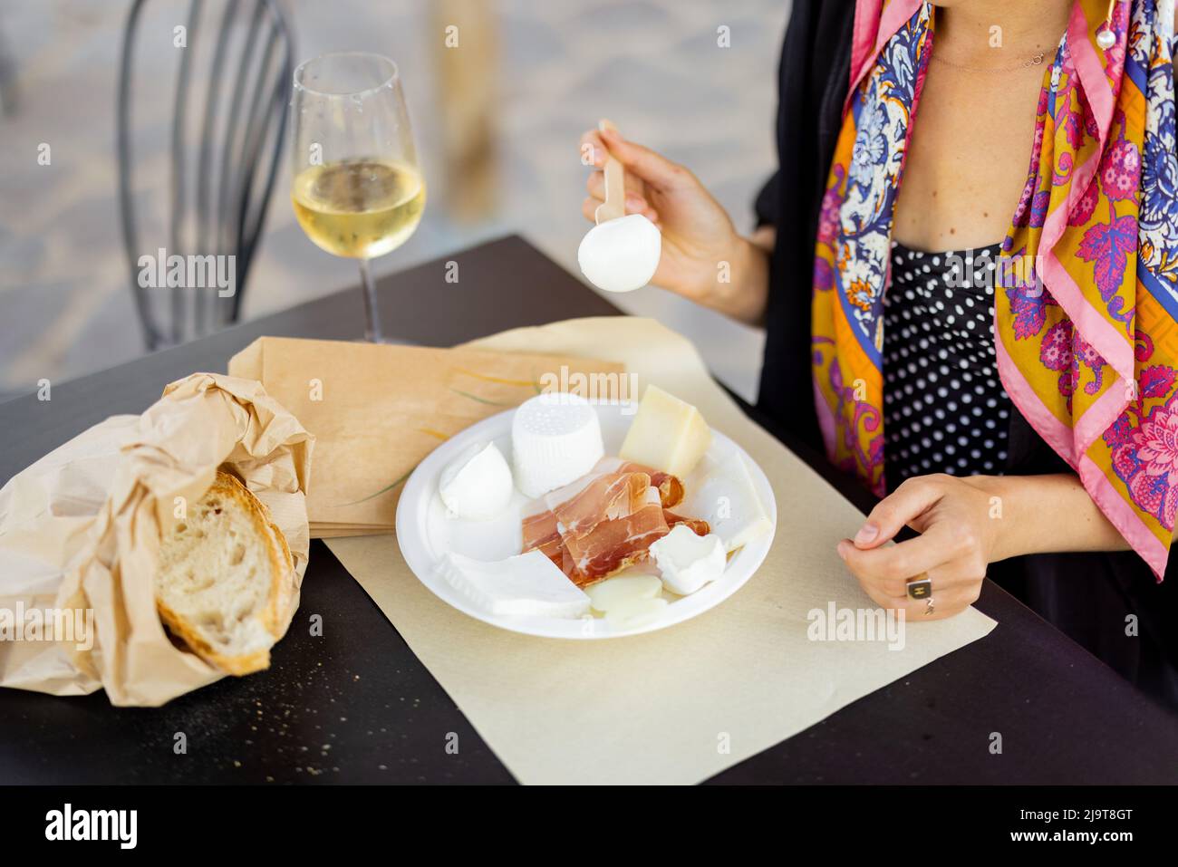 Woman tasting cheese and wine at local farm shop in Italy Stock Photo