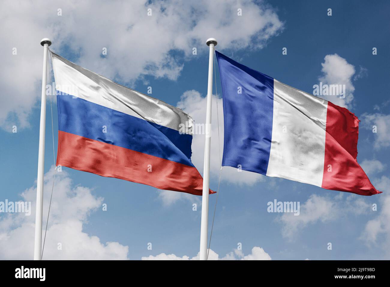 Russia and France two flags on flagpoles and blue cloudy sky background Stock Photo