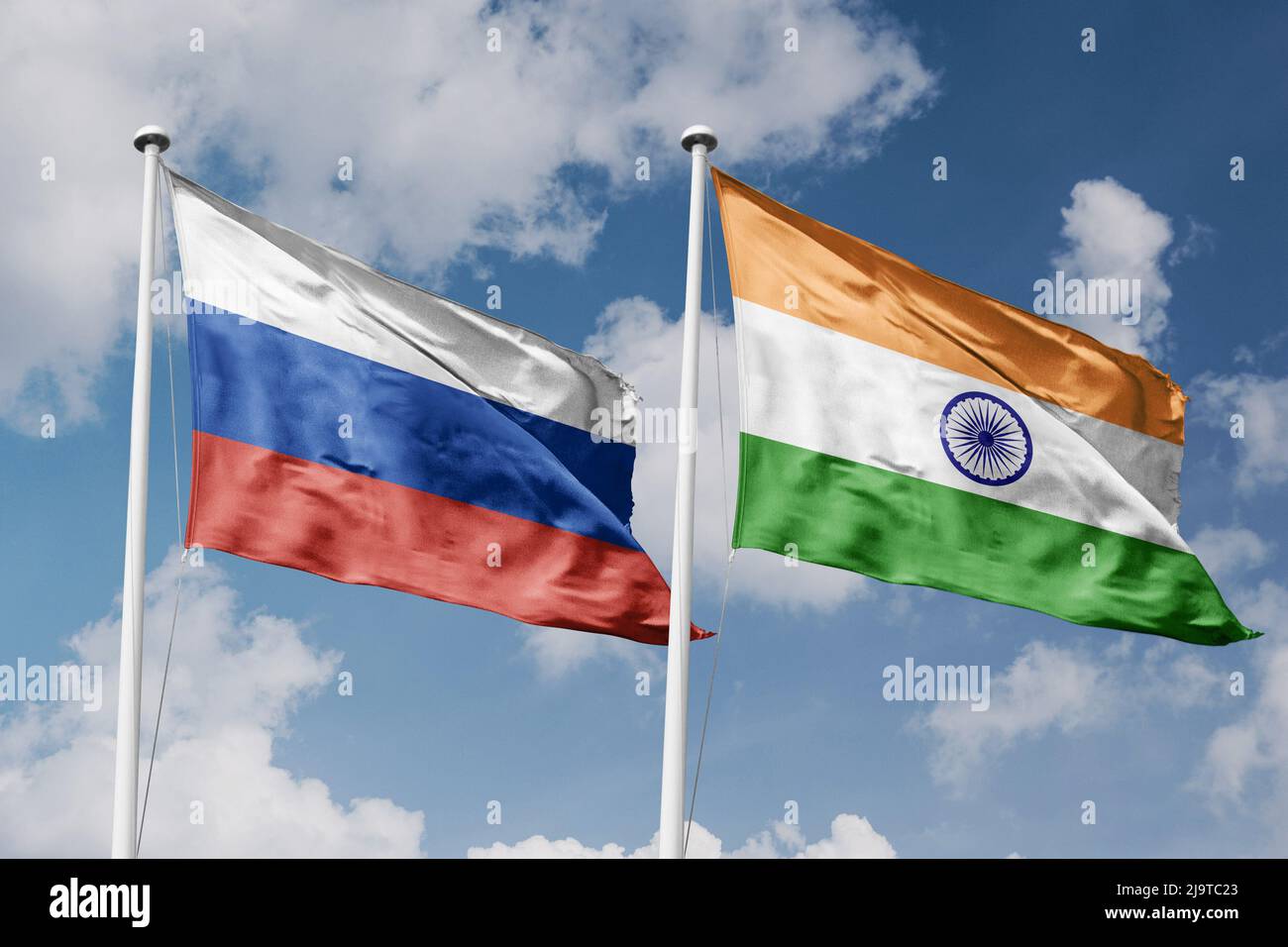 Russia and India two flags on flagpoles and blue cloudy sky background Stock Photo