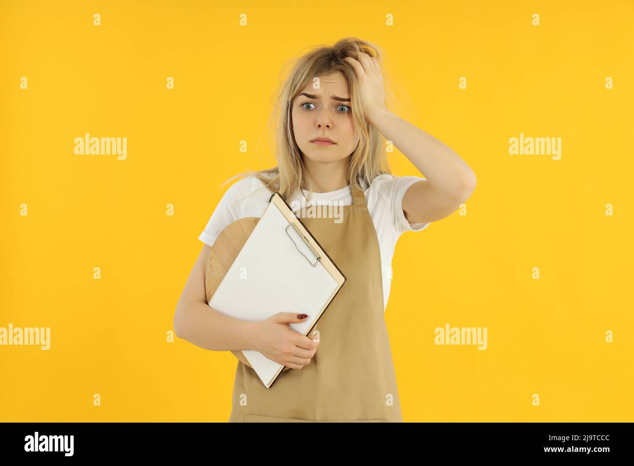 Concept of occupation, young female waiter on yellow background Stock Photo