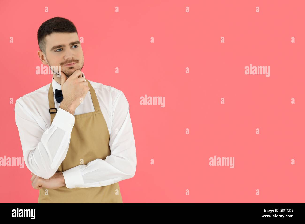 Concept of occupation, young waiter on pink background Stock Photo