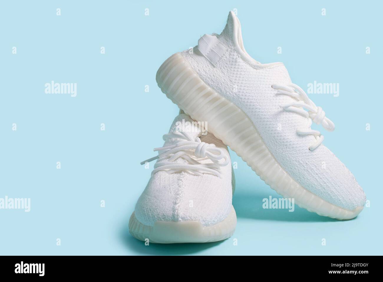 A pair of white sneakers on a blue background Stock Photo