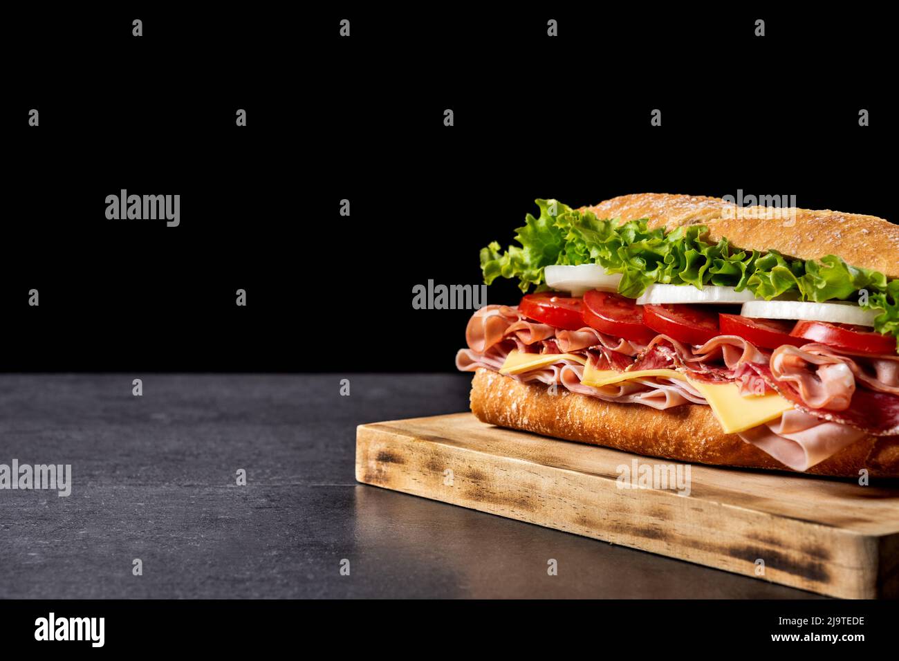 Submarine sandwich with ham, cheese, lettuce, tomatoes,onion