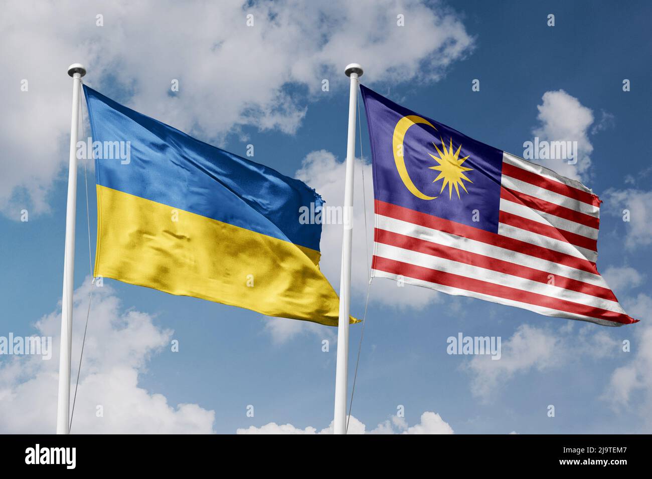 Ukraine and Malaysia two flags on flagpoles and blue cloudy sky background Stock Photo