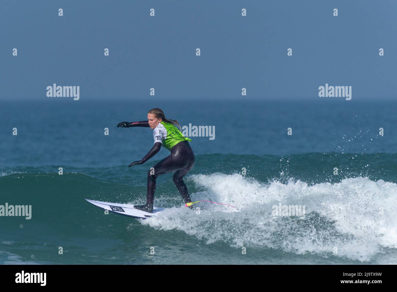 A female surfer competing in a surfing competition at Fistral in Newquay in Cornwall in the UK. Stock Photo