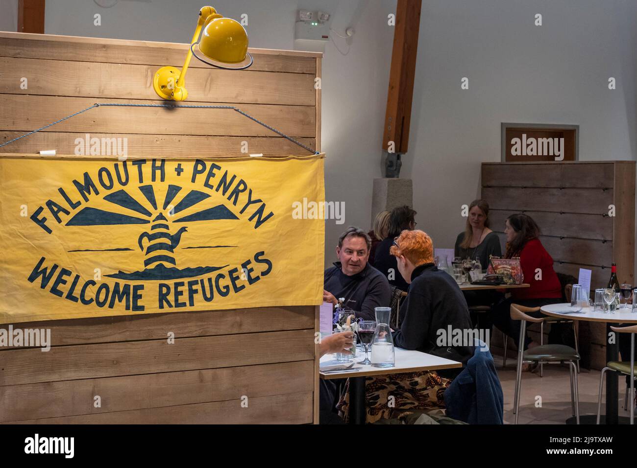 A banner displaying the logo of the charity organisation of the Falmouth and Penryn Welcome Refugees at Trebah Garden in Cornwall in the UK. Stock Photo