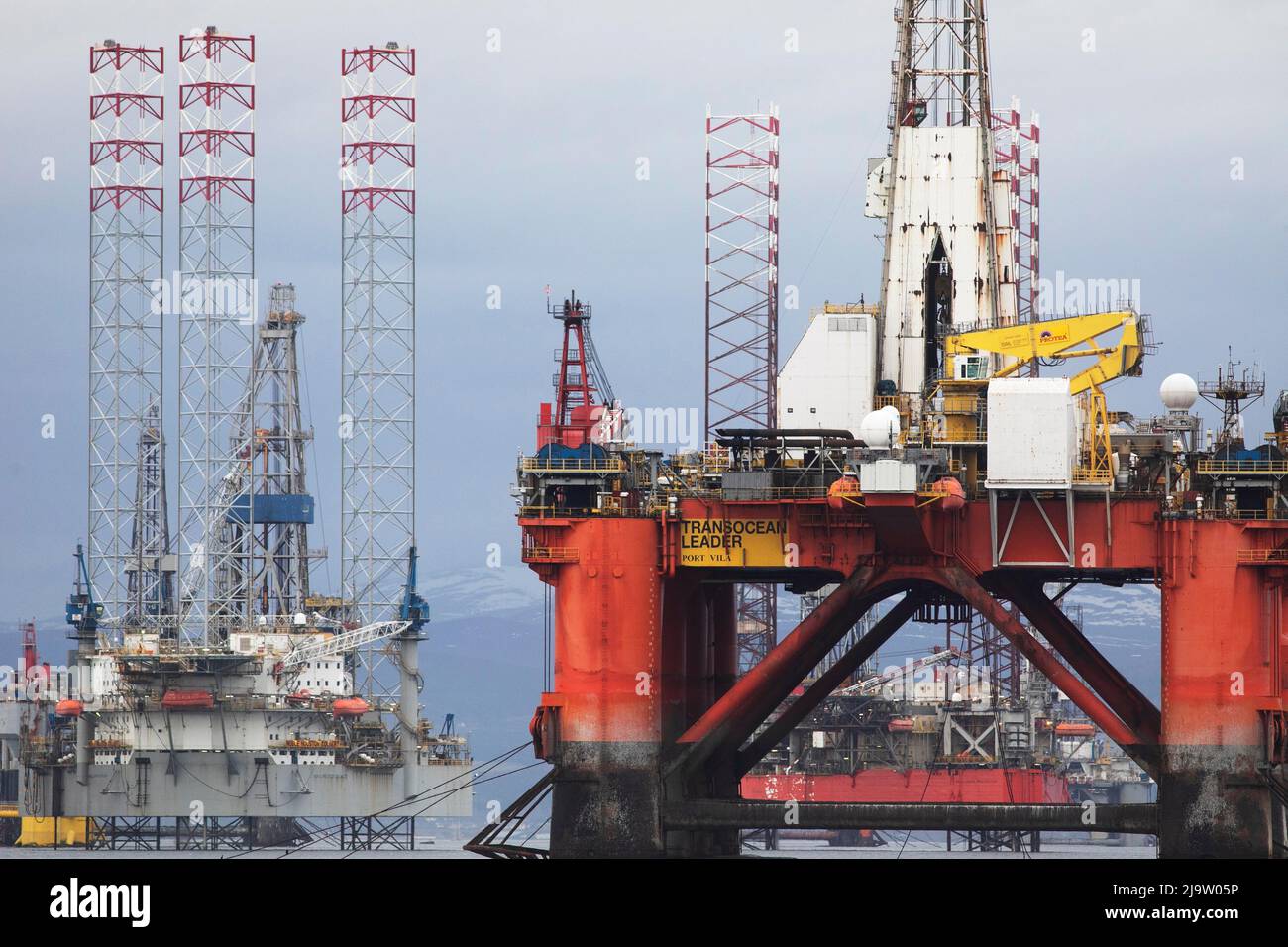 OIL CRISIS.Oil rigs Cromarty Firth, being recommissioned plus wind trubine legs from China . Stock Photo
