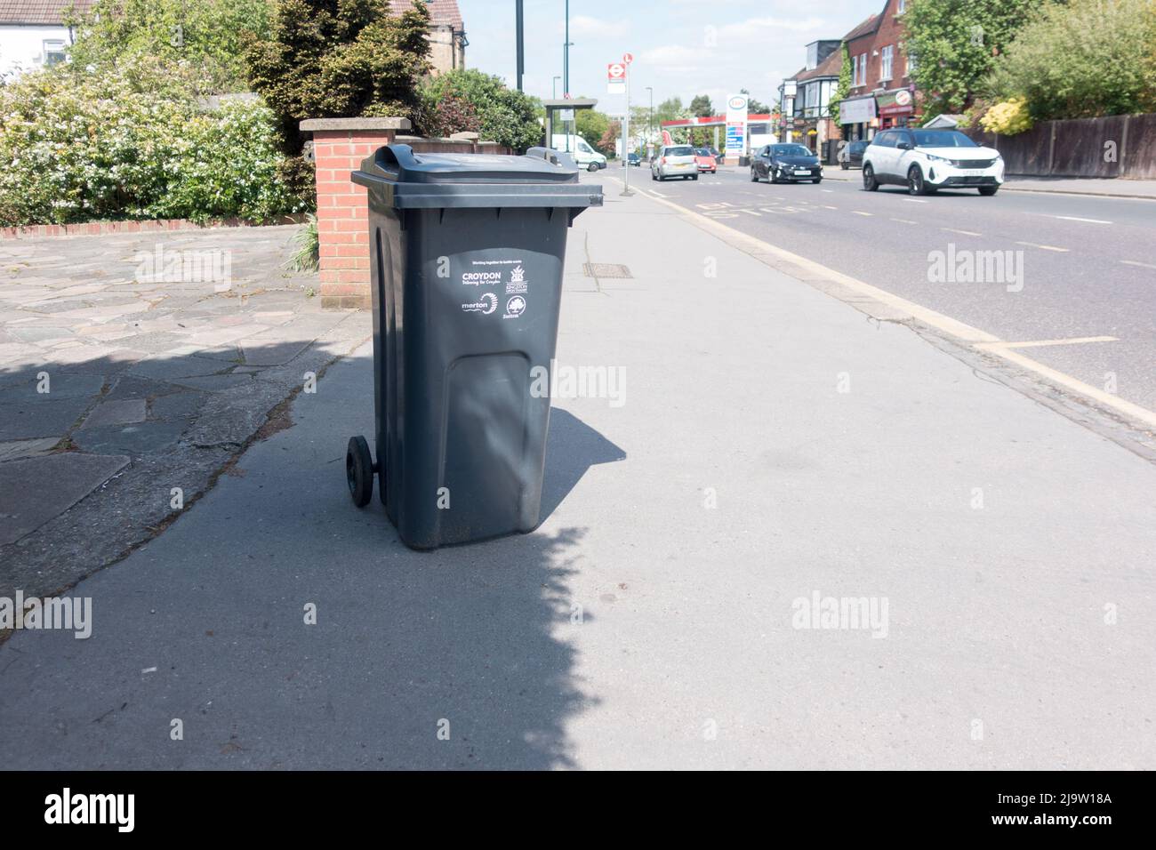 Wheelie bin left on the pavement side walk during a bin collection day in Croydon Stock Photo