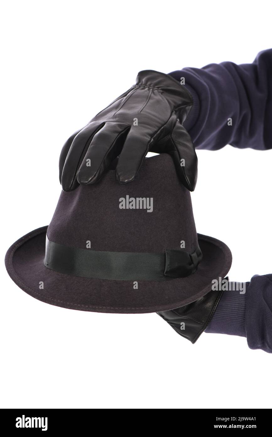 Man wearing black leather glove on white background, closeup. Felt hat in handSide view. High resolution photo. Full depth of field. Stock Photo
