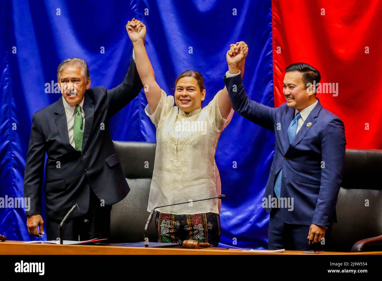 (220525) -- QUEZON CITY, May 25, 2022 (Xinhua) -- Vice President-elect Sara Duterte-Carpio (C) raises hands with the Senate president Vicente Sotto (L) and the House speaker Allan Velasco during her proclamation at the Philippine House of Representatives in Quezon City, the Philippines, on May 25, 2022. The Philippine Congress on Wednesday proclaimed Ferdinand Romualdez Marcos as the winner of the presidential election, succeeding Rodrigo Duterte, who will step down in June after six years in office. The joint session of the Congress also proclaimed Sara Duterte-Carpio, the 43-year-old daug Stock Photo