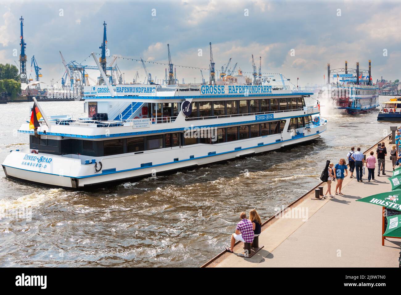 Hamburg, Germany - July 12, 2011 : Hamburg Harbor. Tour boats and passengers waiting for tour boats along the Elbe River in mid summer. Stock Photo