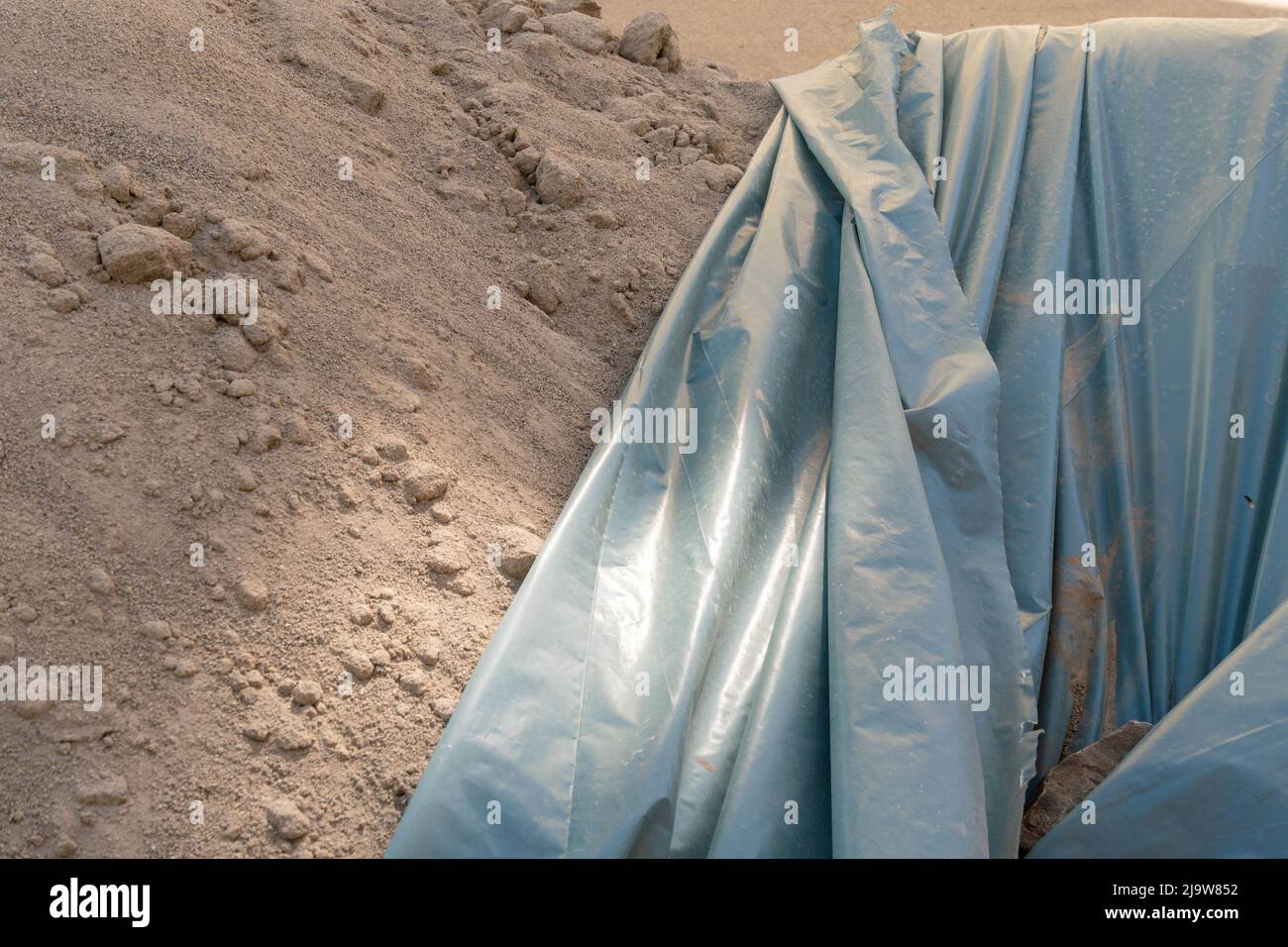 Covered pile of sand on a construction site Stock Photo - Alamy