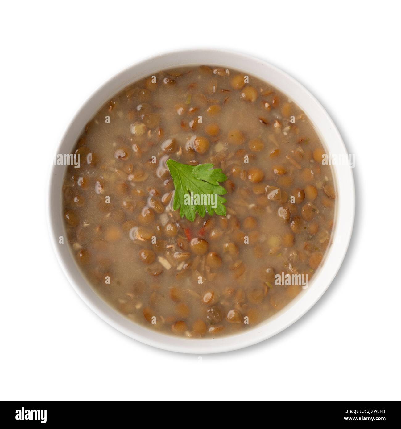 Lentil soup in a bowl with seasoning isolated over white background. Stock Photo