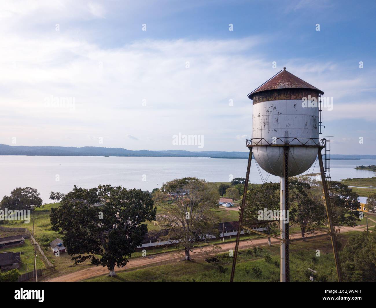 Drone aerial view of Fordlandia city skyline in Amazon rainforest, Brazil. Tapajos river and historic water tank tower. Town built by Henry Ford Stock Photo