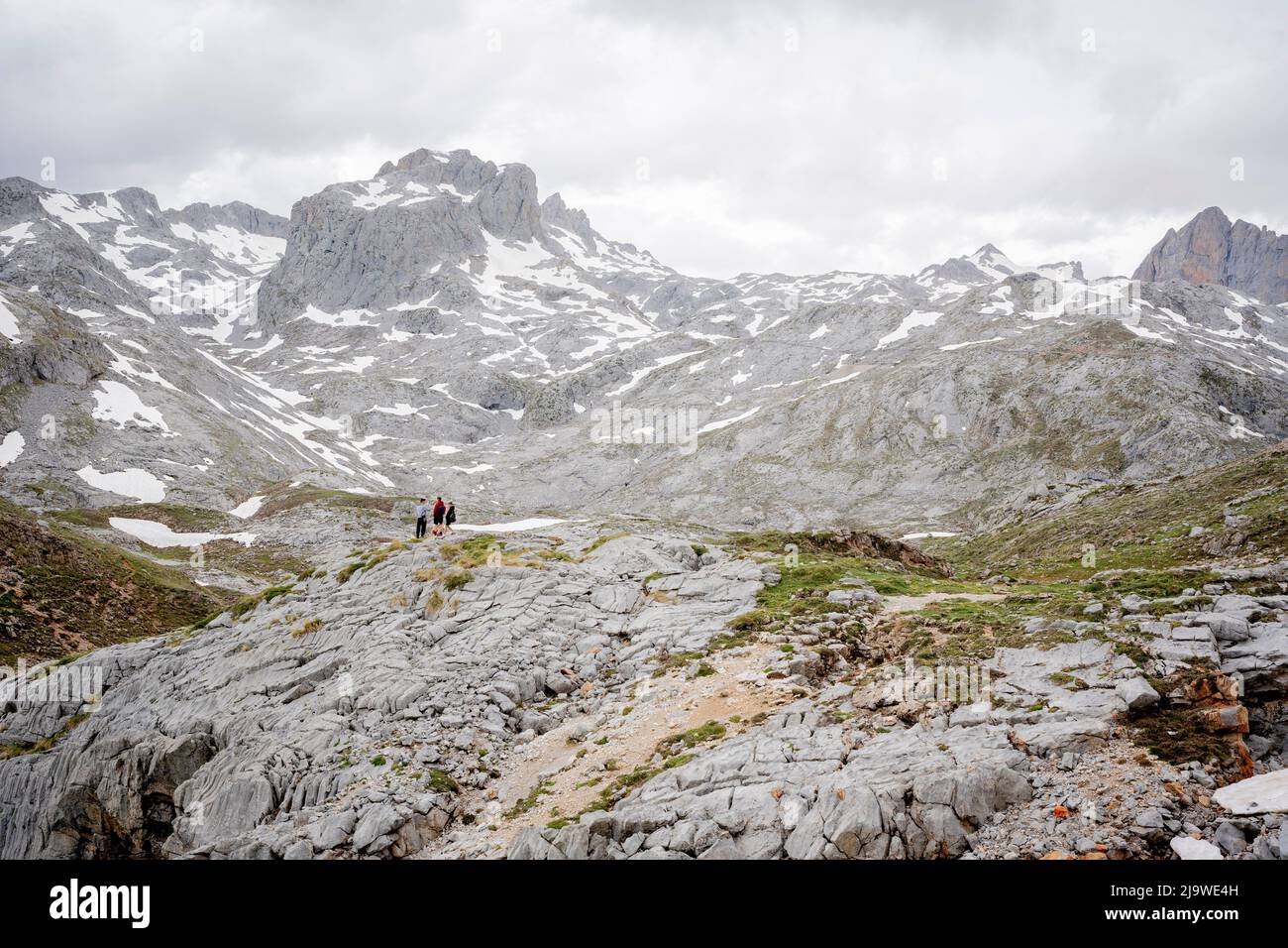 Surrounded by icy mountain peaks, a few members of a school tour group explore the rocky landscape near the cablecar station at Fuente De in the Spanish Picos de Europa National Park, on 18th May 2022, Asturias, Spain. Stock Photo
