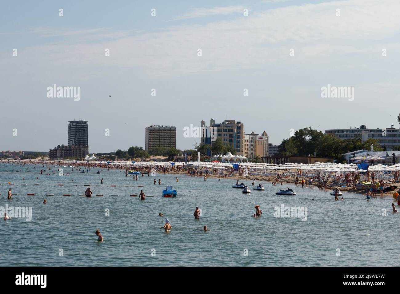 SUNNY BEACH, BULGARIA - JUNE 25, 2015: Seashore in Bulgaria, many people swim in summer in black sea and sunbathe on shore, against background of diff Stock Photo