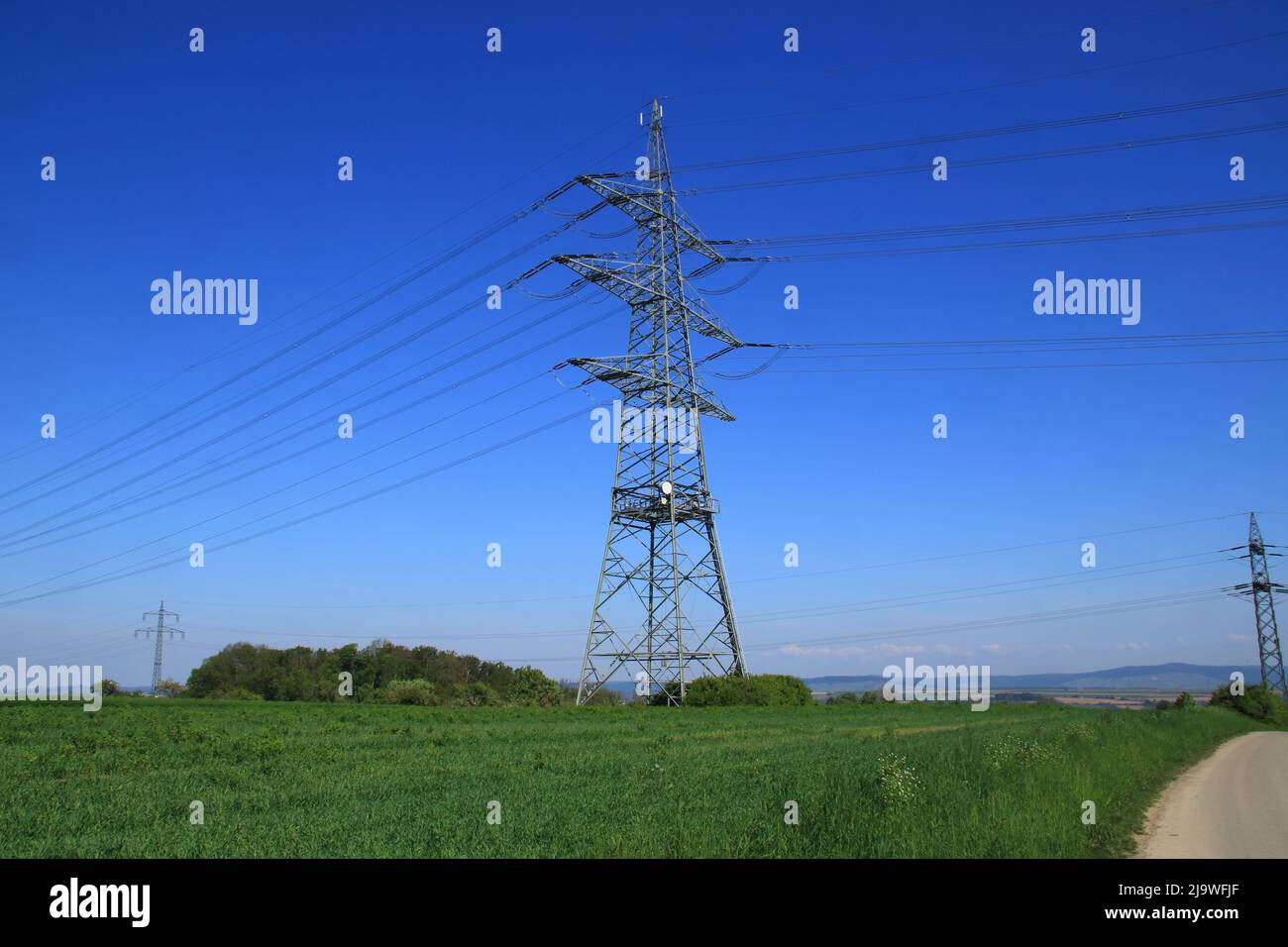 Single high voltage pylon against a blue sky Stock Photo