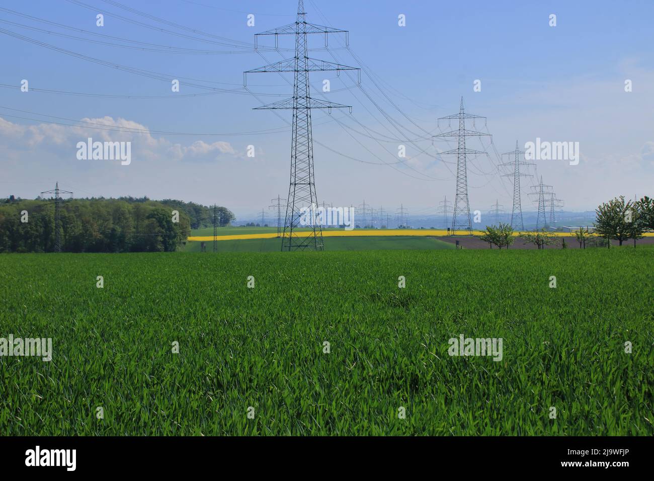 Several high voltage pylons against a blue sky Stock Photo - Alamy