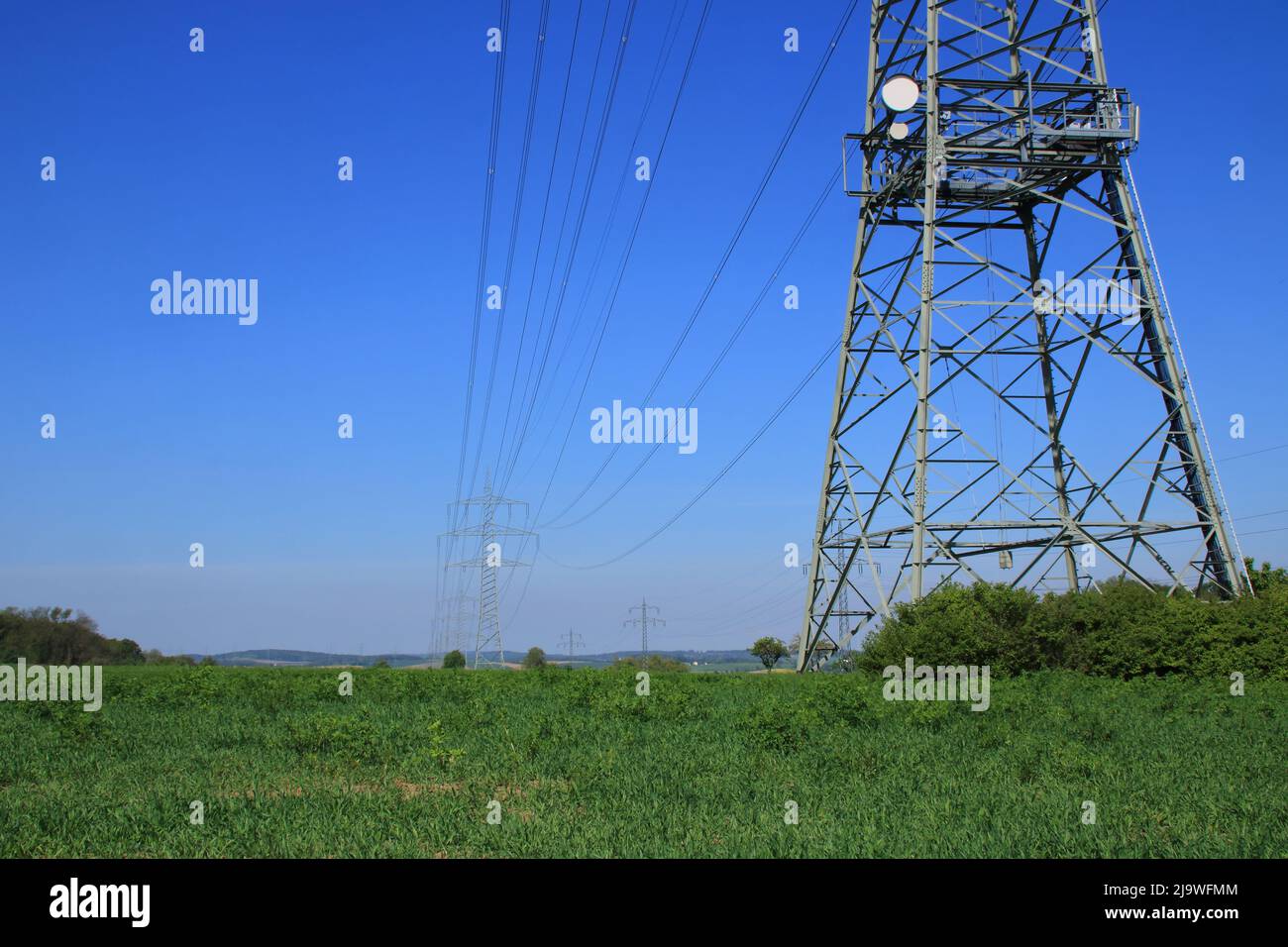 Several high voltage pylons against a blue sky Stock Photo