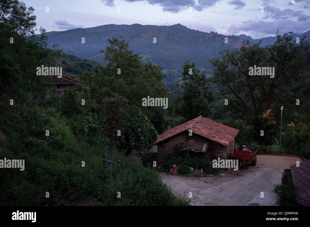 A dawn landscape of farm buildings and mountain foothills in the hamlet of Lon near Potes, a popular tourist gateway for those entering the Spanish Picos de Europa National Park region, on 18th May 2022, Lon, Asturias, Spain. Stock Photo