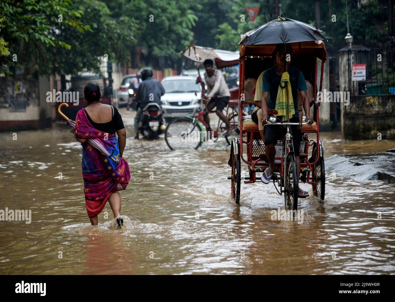 Guwahati, Assam, India. 25th May, 2022. Commuters wades across a flooded street after heavy rains, in Guwahati, Assam, India on 25 May 2022. Waterlogging is a common scene in Guwahati city due to poor drainage system. Credit: David Talukdar/Alamy Live News Stock Photo