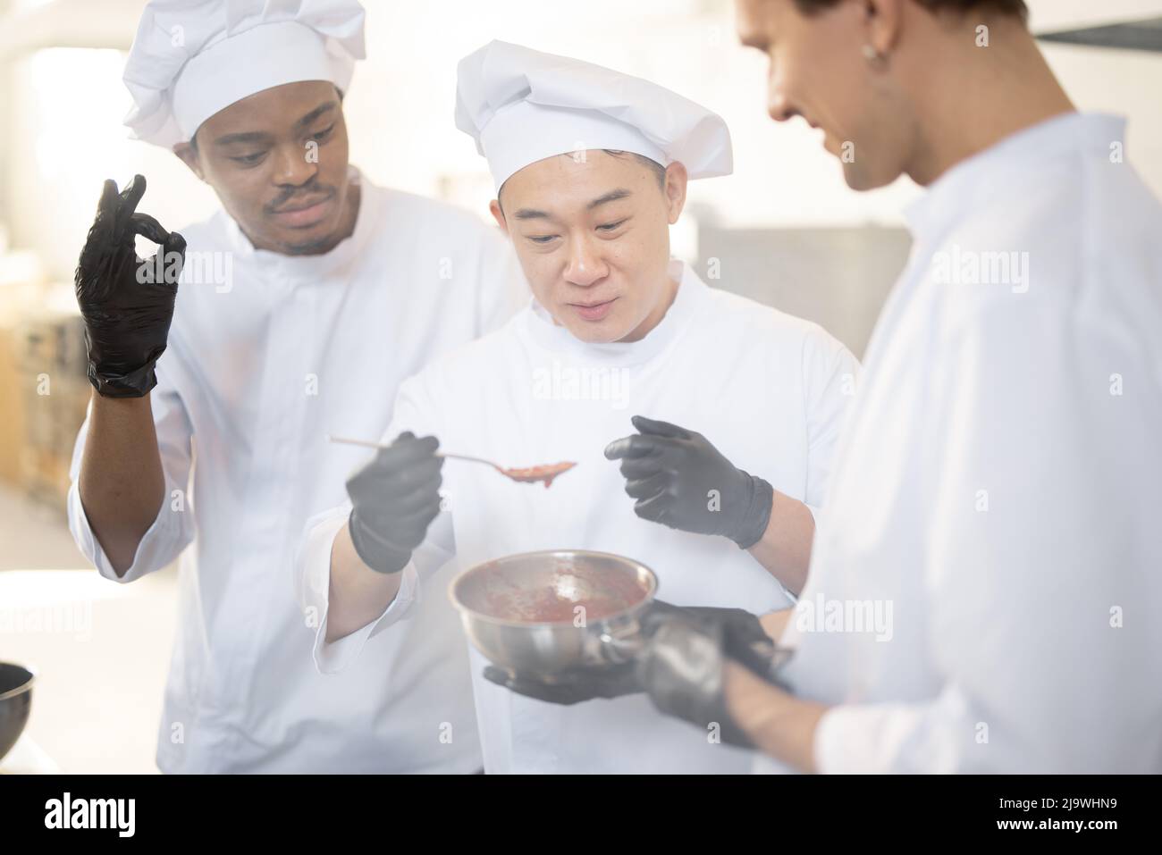 https://c8.alamy.com/comp/2J9WHN9/three-chef-cooks-with-different-ethnicities-tasting-sauce-with-a-spoon-while-cooking-in-the-kitchen-teamwork-and-cooking-delicious-food-at-restaurant-2J9WHN9.jpg