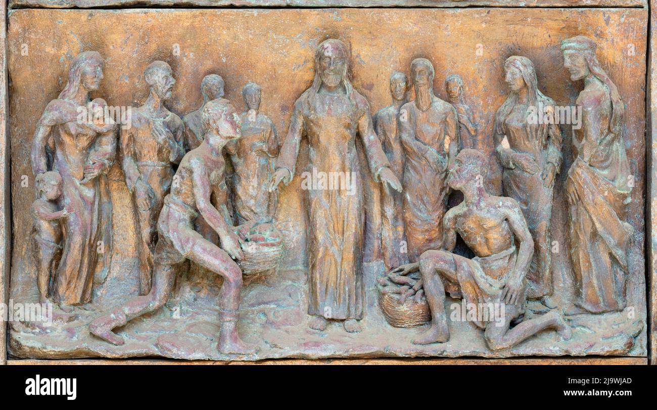 MONOPOLI, ITALY - MARCH 6, 2022: The bronze relief  the Miracle of Multiplication on the gate of church Chiesa di Sacro Cuore Stock Photo