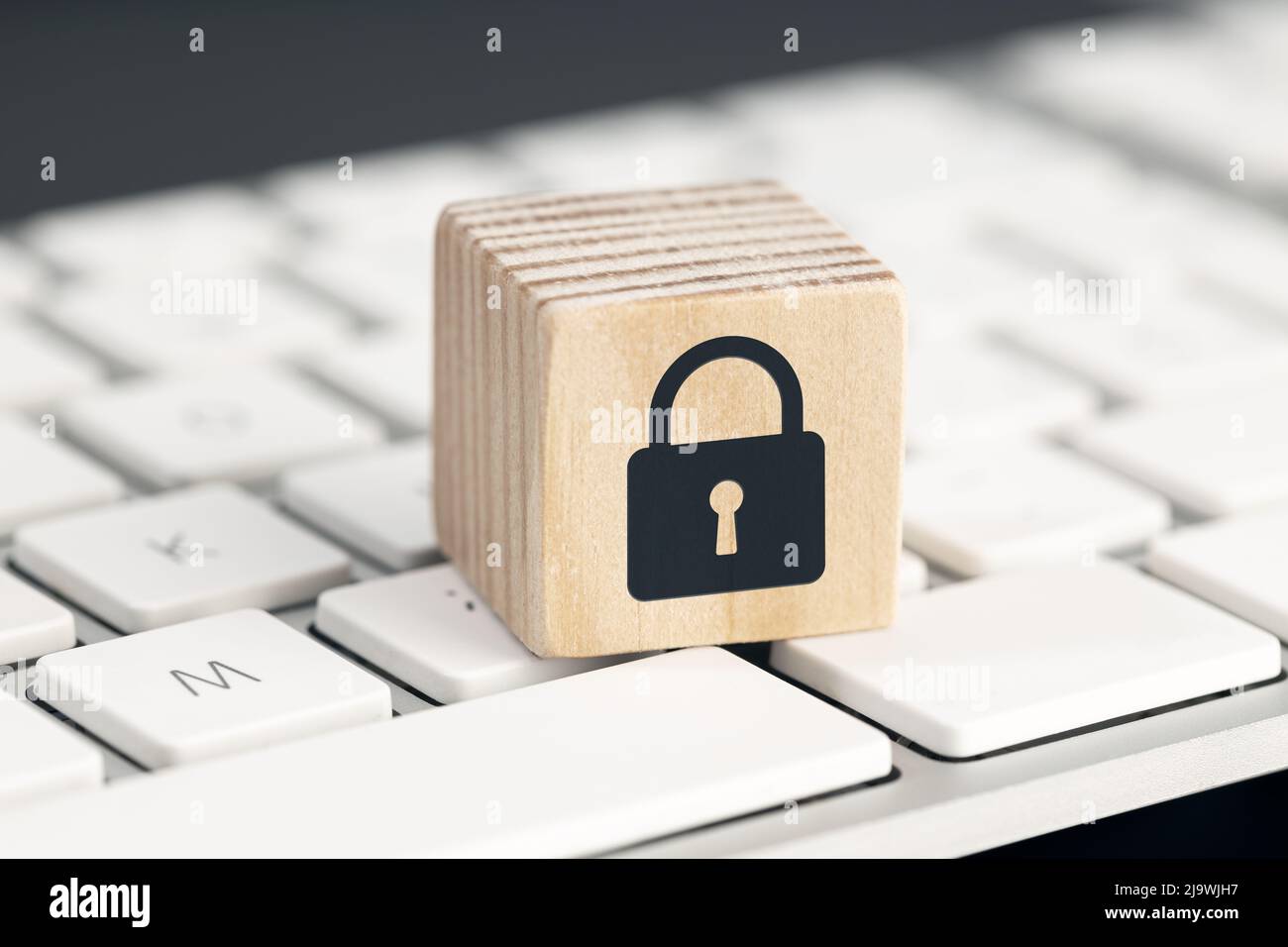 Computer Security protection concept. Cyber attack protection. Closed padlock icon on wooden block on computer keyboard Stock Photo