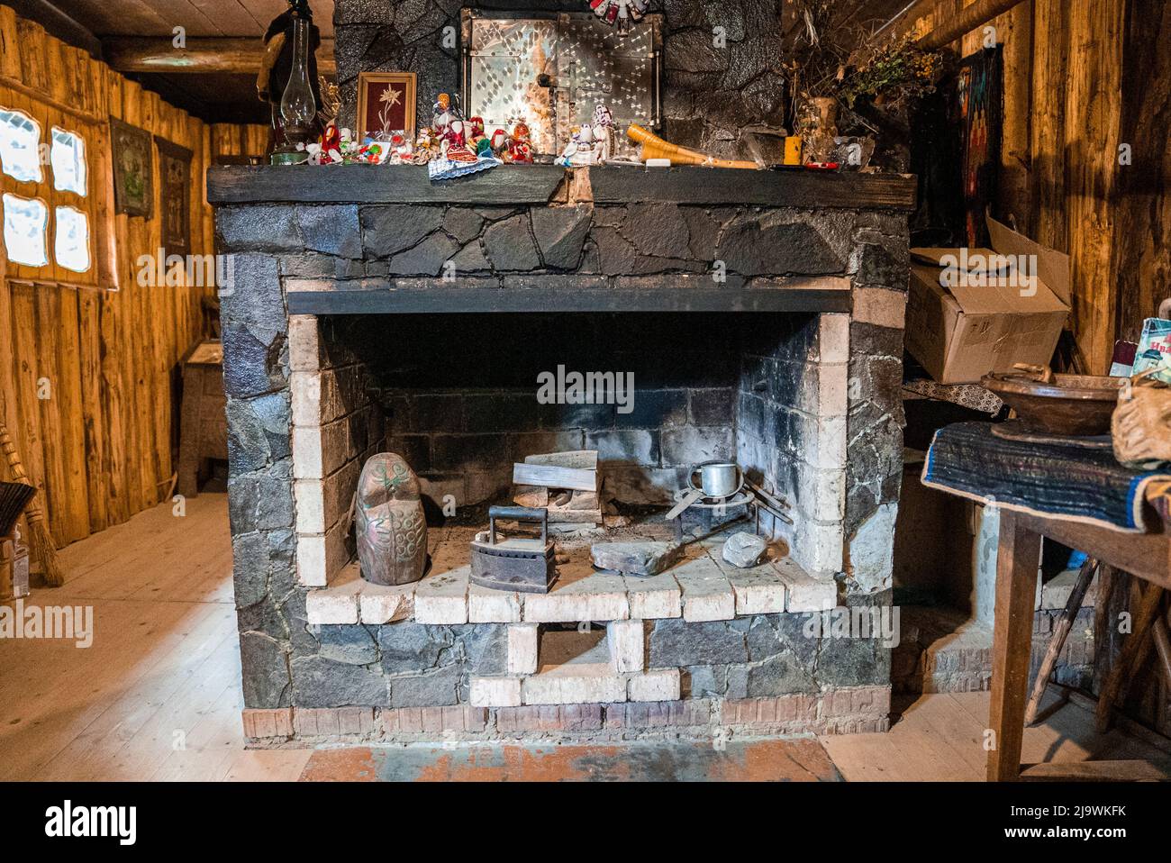 Stone brick wall fireplace with antique tools in abandoned room Stock Photo
