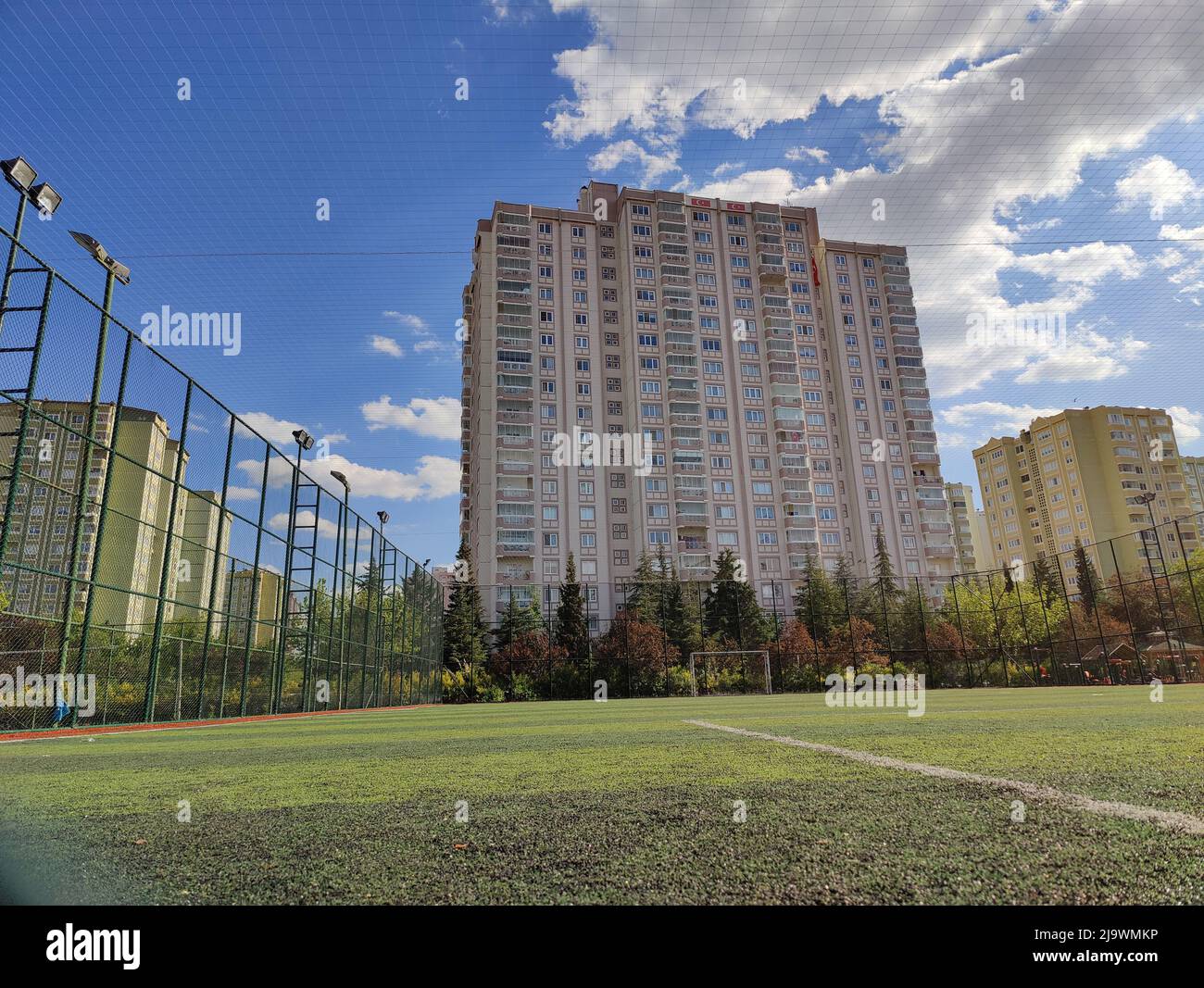 tall building behind football field fence Stock Photo