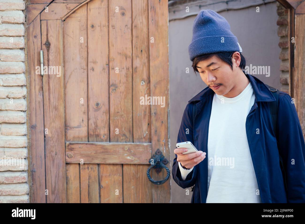 cute tourist from Korea with a backpack looking into the phone Stock Photo