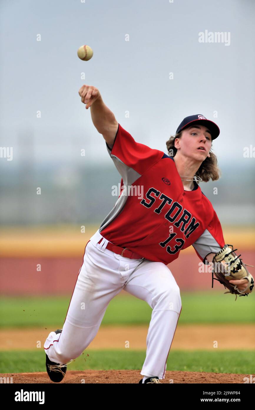 USA. Pitcher delivering a pitch to a waiting batter during a high school baseball game. Stock Photo