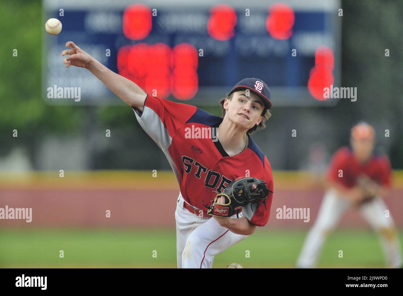USA. Pitcher delivering a pitch to a waiting batter during a high school baseball game. Stock Photo