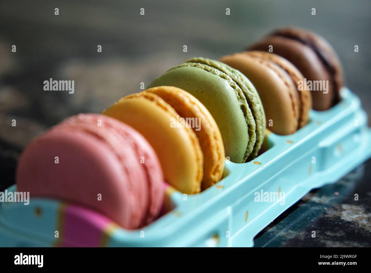 a stack of colorful macarons on marble table Stock Photo
