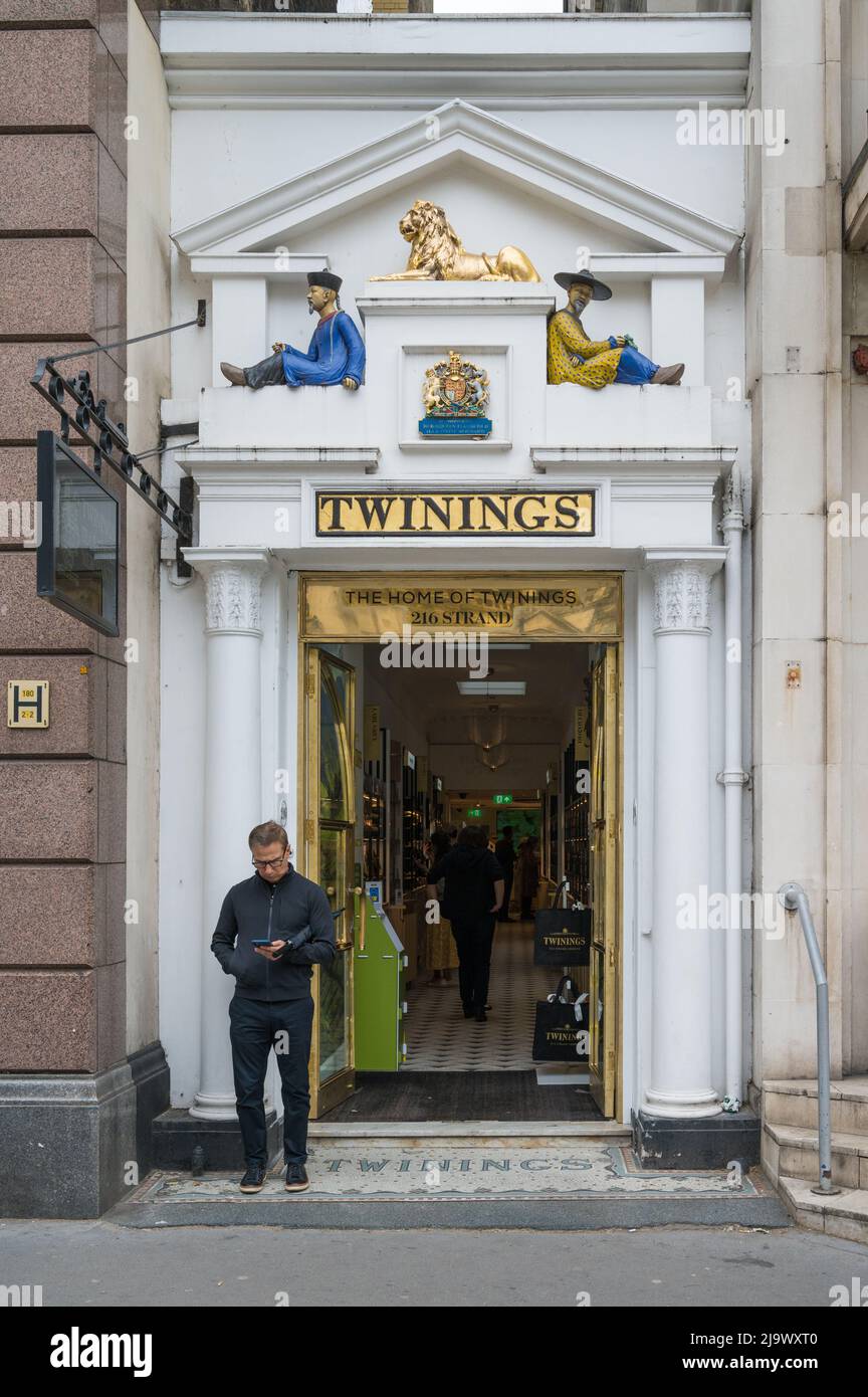 A lone man stands outside the decorative entrance to the Twinings