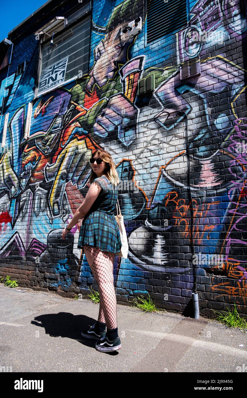 Girl walking through a graffited back street in Brighton Stock Photo