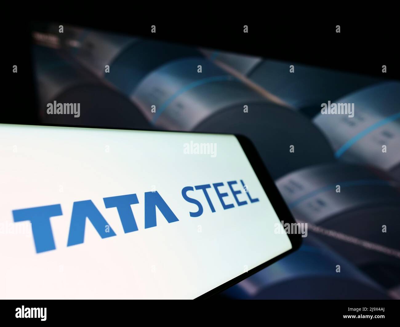 Mobile phone with logo of Indian steelmaking company Tata Steel Limited on screen in front of website. Focus on center-right of phone display. Stock Photo