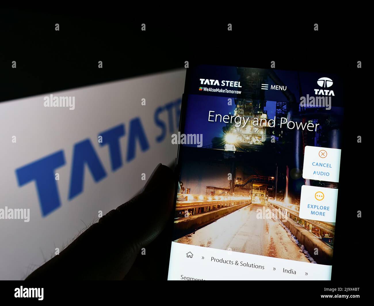 Person holding cellphone with webpage of Indian steelmaking company Tata Steel Limited on screen with logo. Focus on center of phone display. Stock Photo