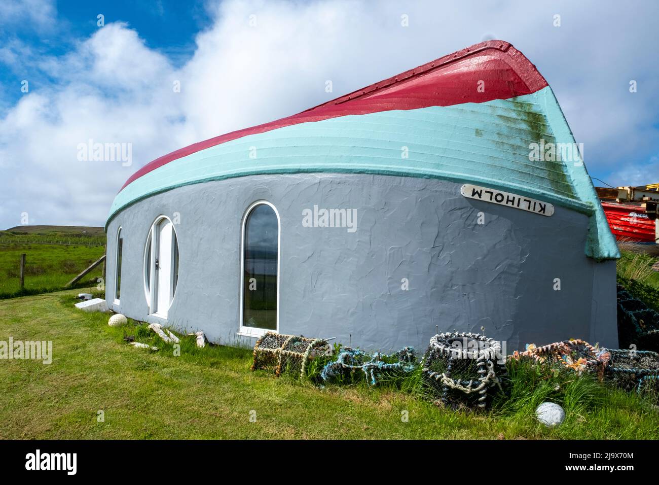 Quirky boathouse construction, Island of Rousay using an upturned fishing boat as a roof for a building with view over Wyre Sound, Orkney, Scotland. Stock Photo