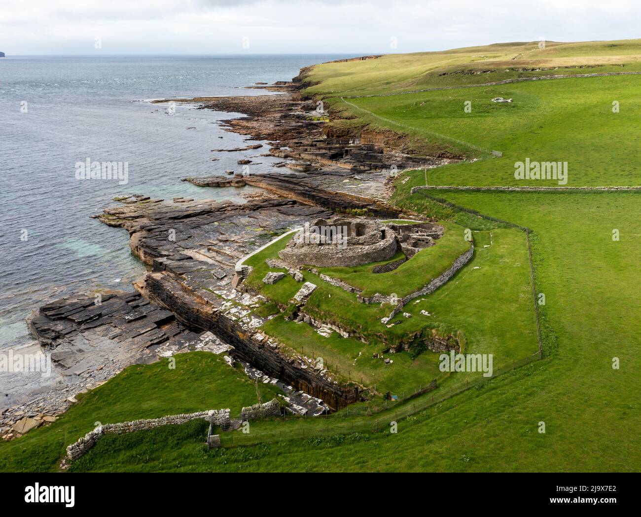 Aerial view of Midhowe Iron Age Broch on the SW coast of Rousay Island overlooking Eynhallow Sound & Orkney Mainland, Scotland, UK Stock Photo