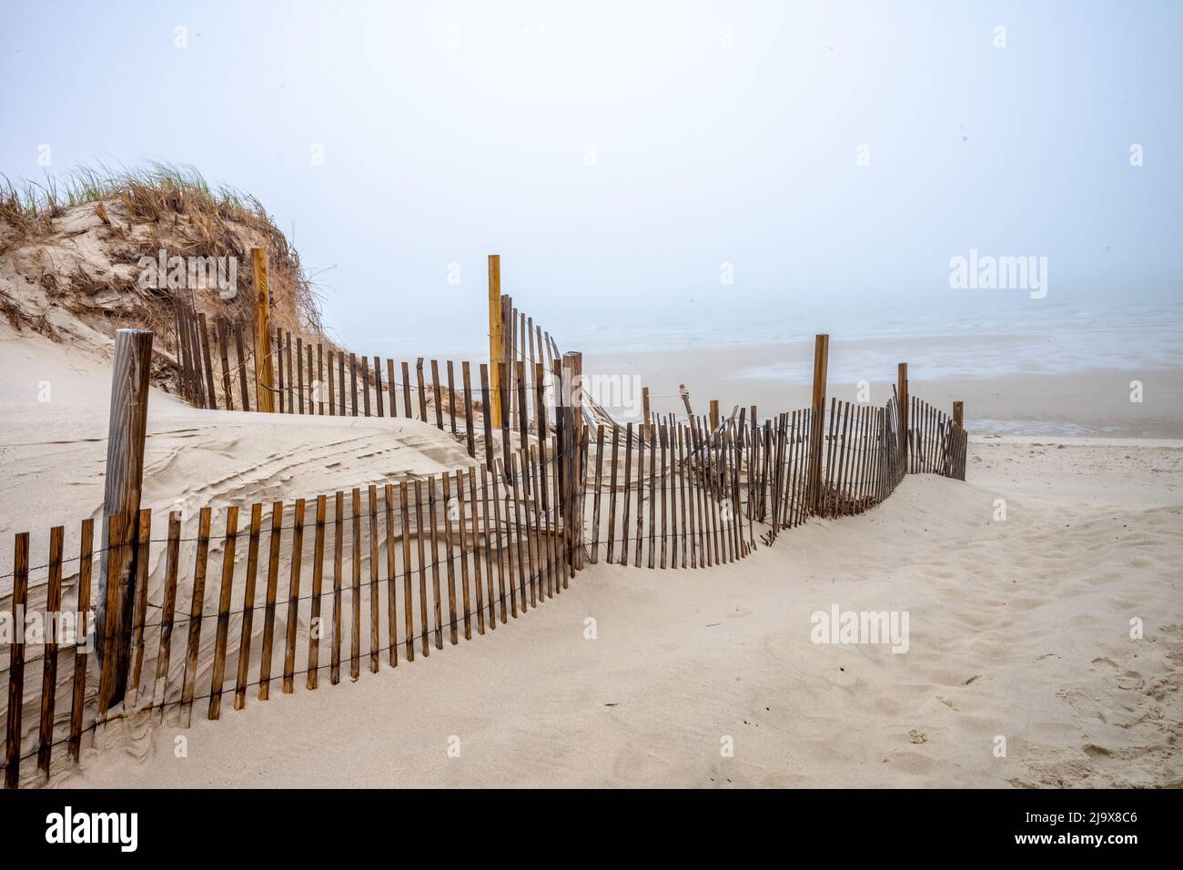 There is one morning a month that starts off with a heavy fog That is the  morning that you can walk on the beach alone and enjoy the days stillness Stock Photo
