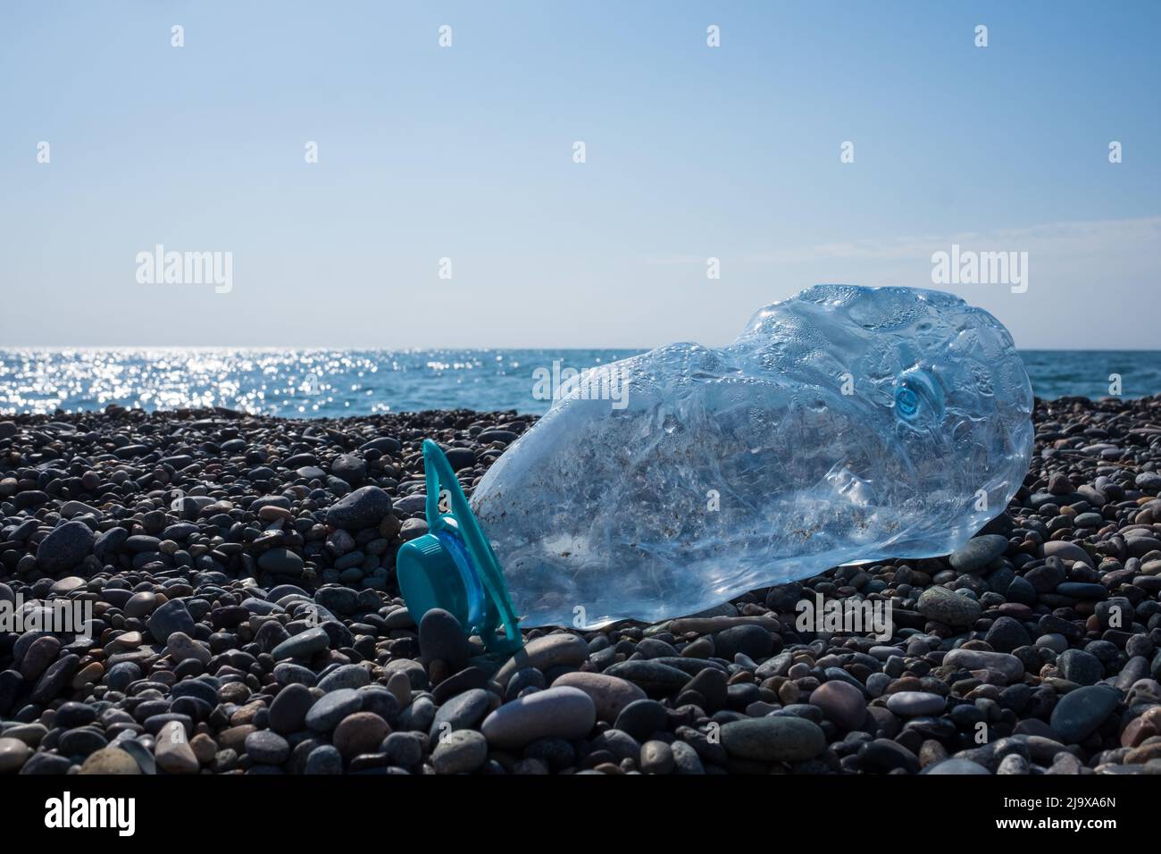 Empty used plastic bottle on beach background. Environmental pollution concept Stock Photo