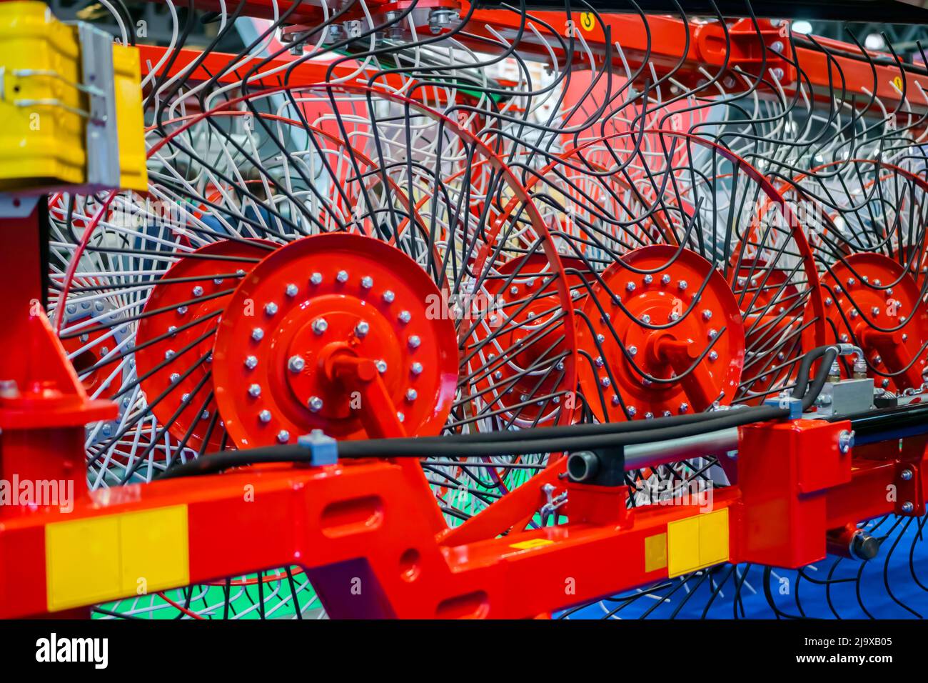 Red tractor rotary wheel hay and tedding rakes at farming exhibition ...