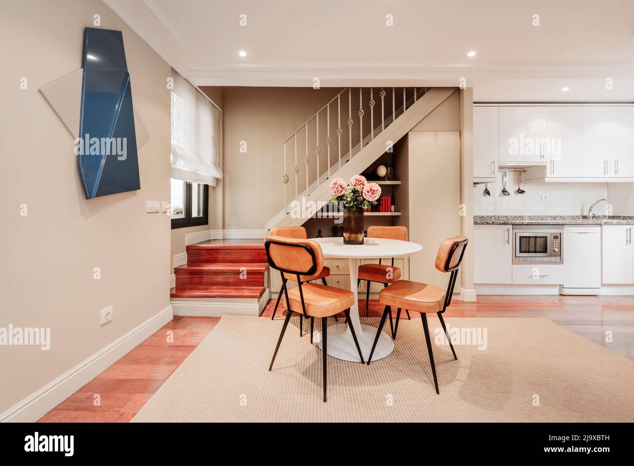 Living room with round white dining table with tobacco colored