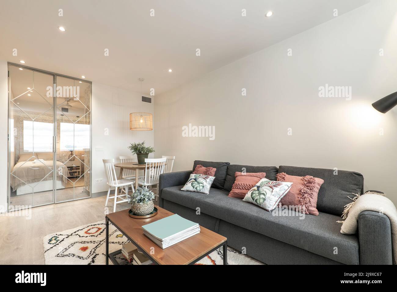Living room with large sofa bed with cushions, wood and metal side