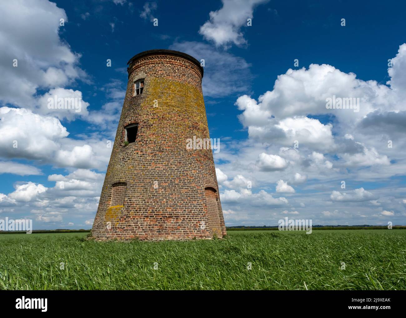 Derelict windmill in a farm field in Lincolnshire under a cloudy sky Stock Photo
