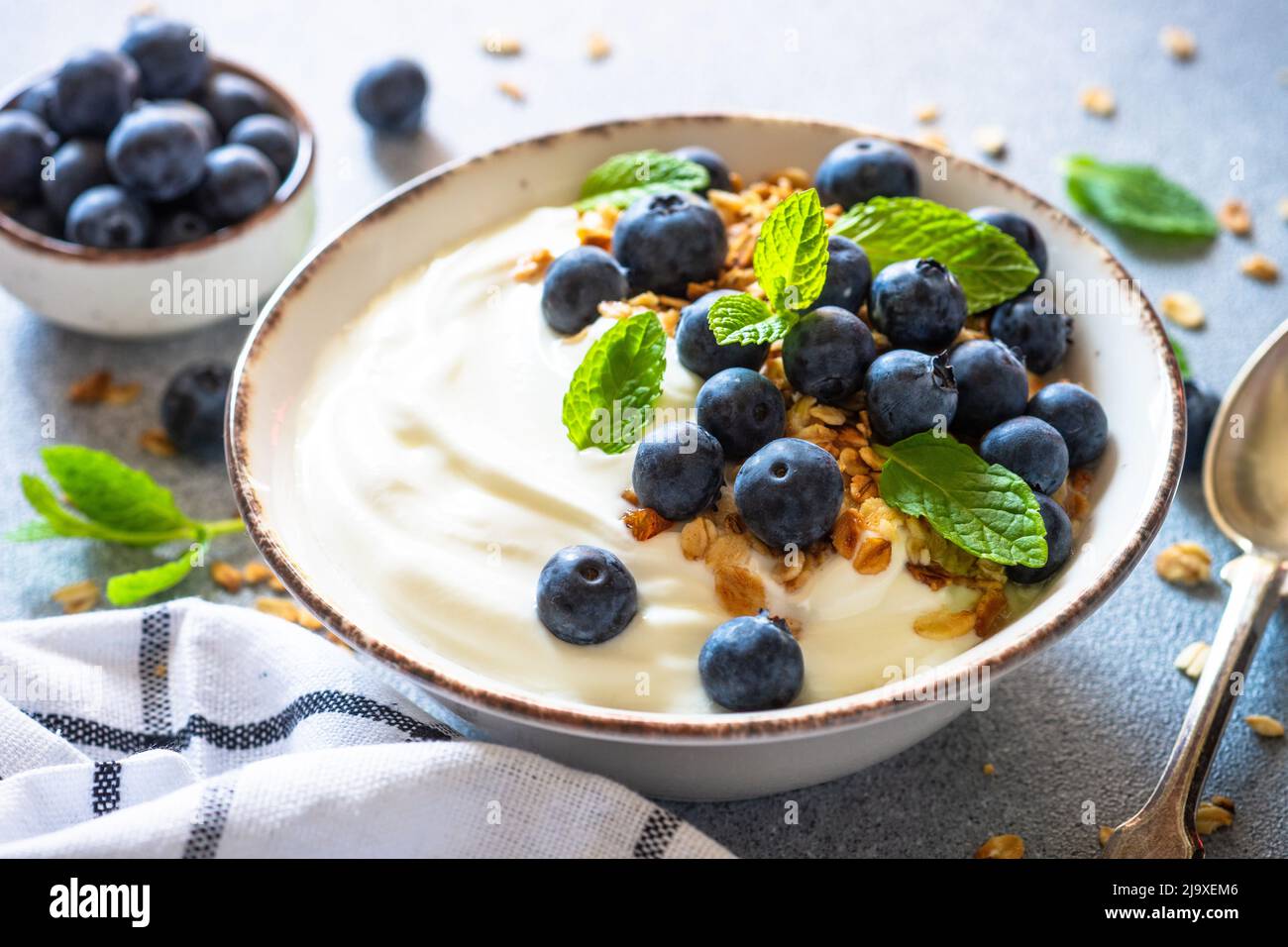 Greek Yogurt, granola and blueberry at light stone table Stock Photo