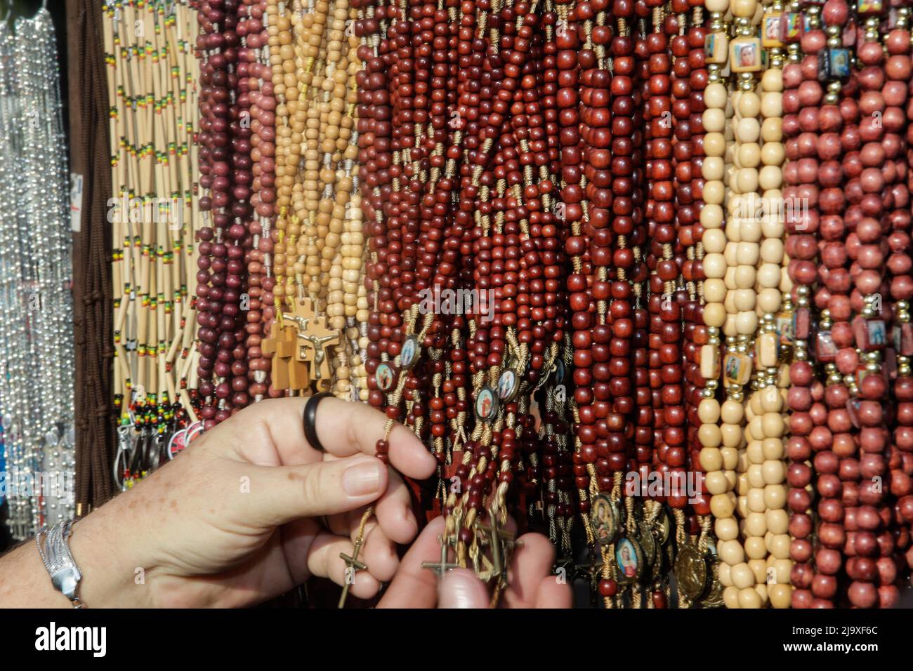 Hands touching rosaries during the festivities of Círio de Nazaré, Marian procession that happens every October in Belém, Pará, Brazil. Stock Photo